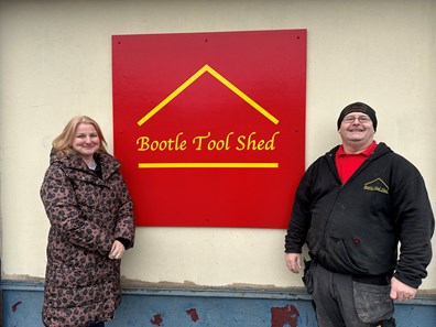 Cllr Trish Hardy and Eddy Flynn standing in front of the Bootle Tool Shed sign