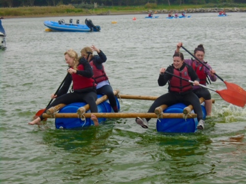 A team riding their raft they built in the Wipeout challenge