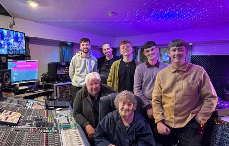 People in front of a sound studio mixing desk