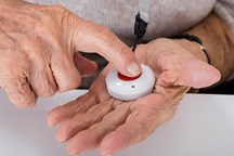 A person pressing a button held in their hand
