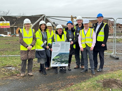 The Sandbrook coproduction group stood on the development site in high-vis and hard hats.