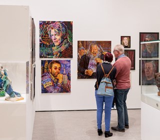 Visitors looking at artworks in the Sefton Open 2023 exhibition