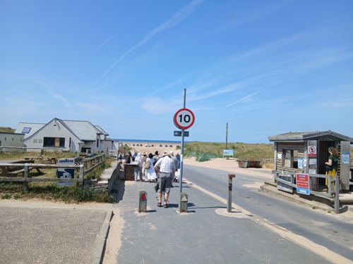 People walking onto Ainsdale Beach on a sunny day
