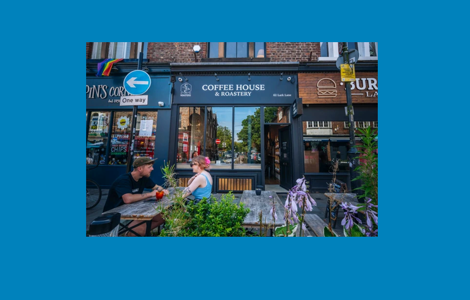 Crosby Coffee House & Roastery frontage with outdoor seating on a bustling high street.