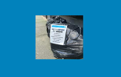 Bags of rubbish with sign to not fly-tip 